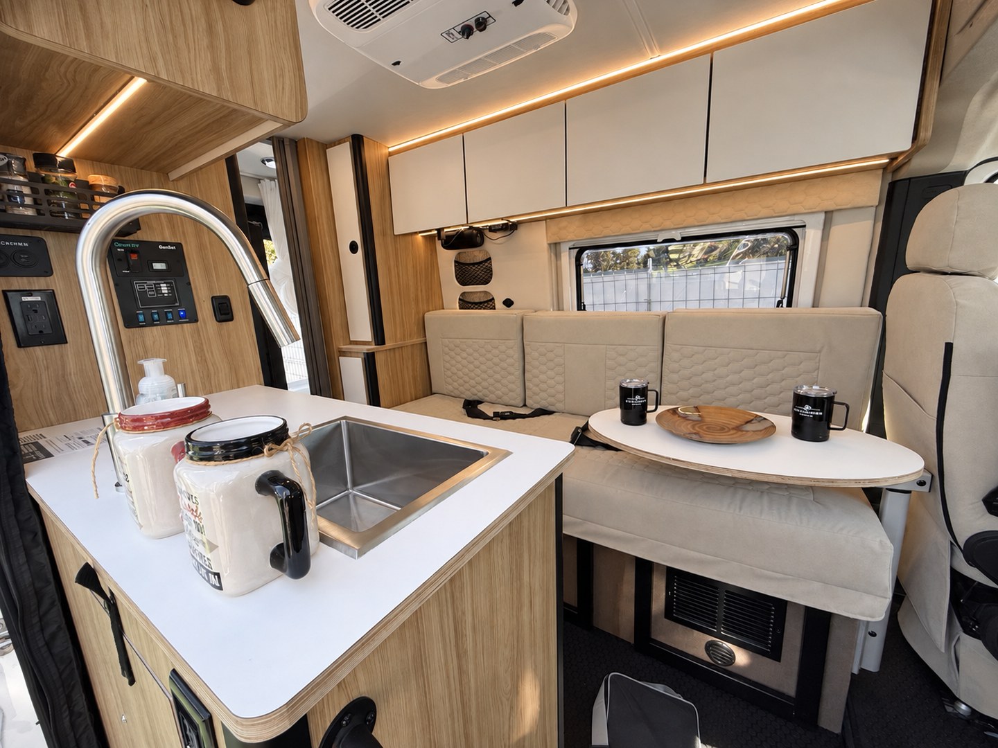 Camper van kitchen counter beside a sofa and dining table