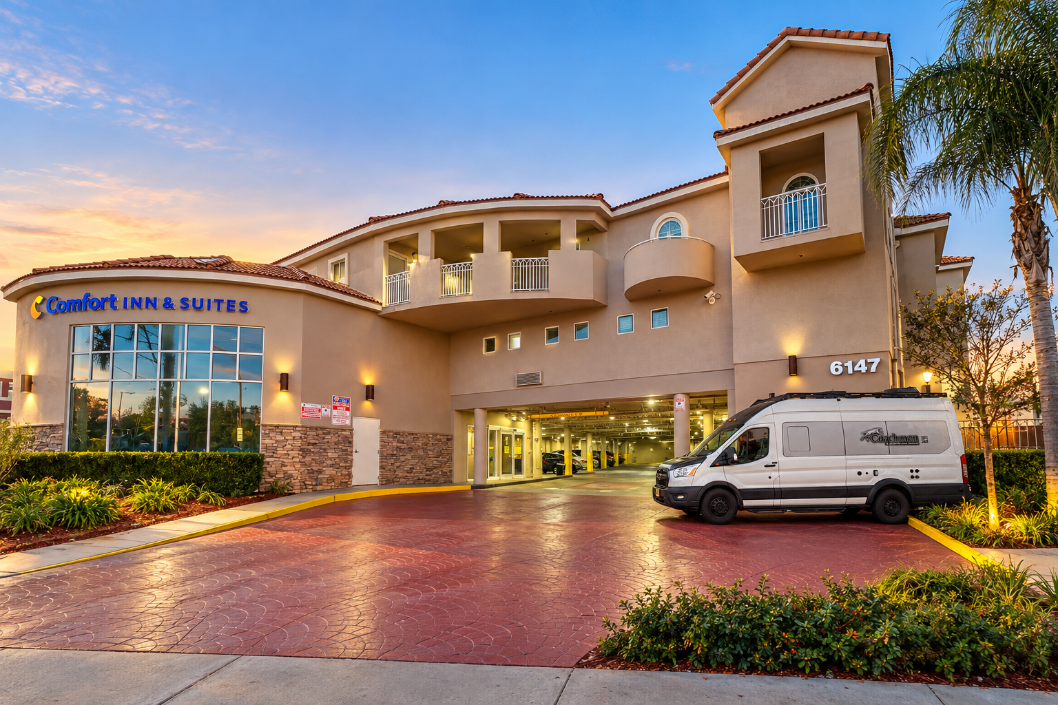 Camper van arriving at a Comfort Inn & Suites hotel at sunset