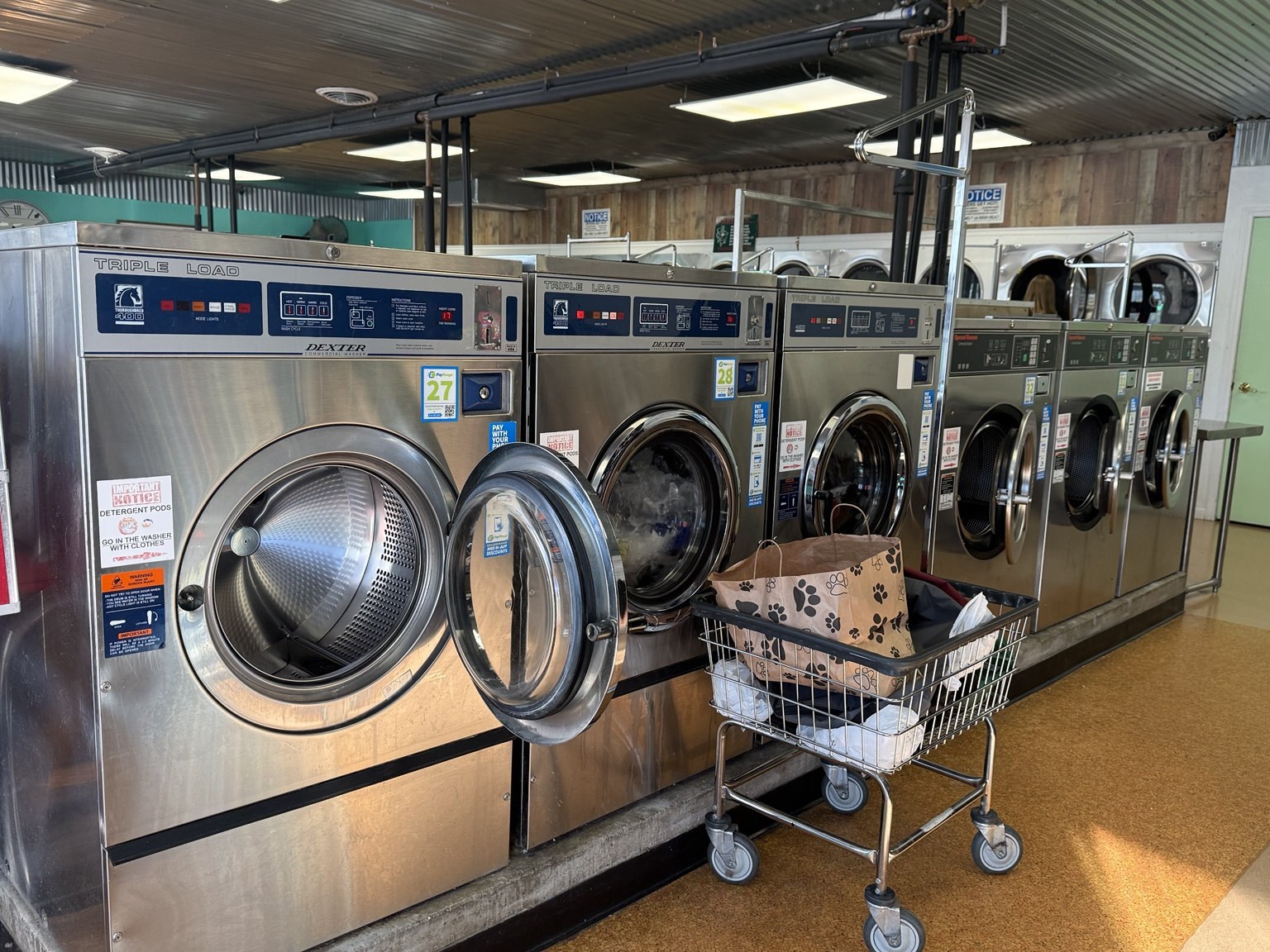 Open washing machine with a laundry cart at the Elkhart laundromat